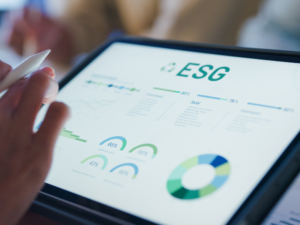 Main utilisant une tablette pour analyser des indicateurs ESG – transition durable numérique.