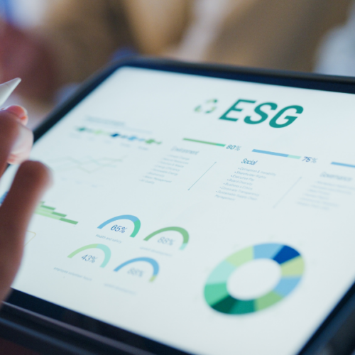 Main utilisant une tablette pour analyser des indicateurs ESG – transition durable numérique.