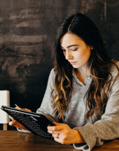 Femme entrepreneure concentrée lisant des documents professionnels dans un bureau moderne.