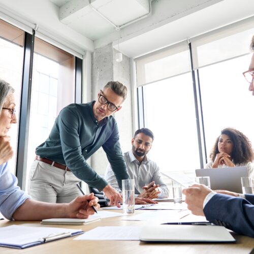 Un chef d'entreprise caucasien âgé de sexe masculin, avec diverses équipes de collègues, un groupe de gestionnaires exécutifs lors de la réunion. Des professionnels du milieu des affaires travaillant ensemble à l'élaboration d'un plan de recherche dans une salle de conseil.