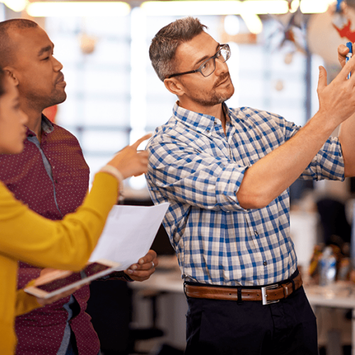 Équipe de professionnels discutant et planifiant une stratégie énergétique lors d’une formation sur la transition énergétique des PME.