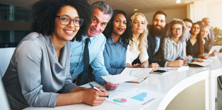 Groupe de professionnels souriants en réunion, illustrant les partenariats privés au service du développement économique des Alpes-Maritimes.