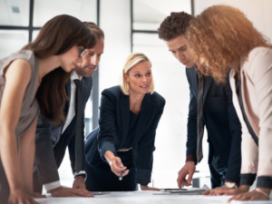 Illustration d’une session de formation à la création d’entreprise avec tableau de stratégie, échanges et planification de projet.