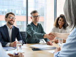 Réunion de création d’entreprise en France : futurs associés se serrant la main après une discussion sur le lancement d’un projet.