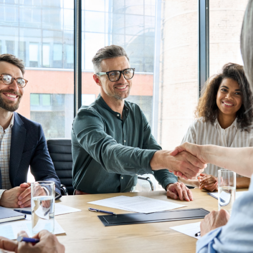 Réunion de création d’entreprise en France : futurs associés se serrant la main après une discussion sur le lancement d’un projet.