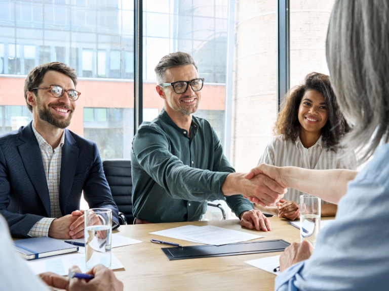 Réunion de création d’entreprise en France : futurs associés se serrant la main après une discussion sur le lancement d’un projet.