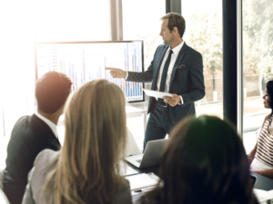 Un entrepreneur présente un graphique comparatif sur les statuts d'auto-entreprise et de micro-entreprise lors d'une réunion professionnelle.