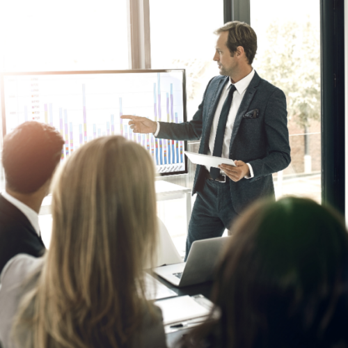 Un entrepreneur présente un graphique comparatif sur les statuts d'auto-entreprise et de micro-entreprise lors d'une réunion professionnelle.