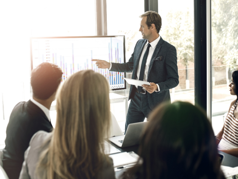 Un entrepreneur présente un graphique comparatif sur les statuts d'auto-entreprise et de micro-entreprise lors d'une réunion professionnelle.